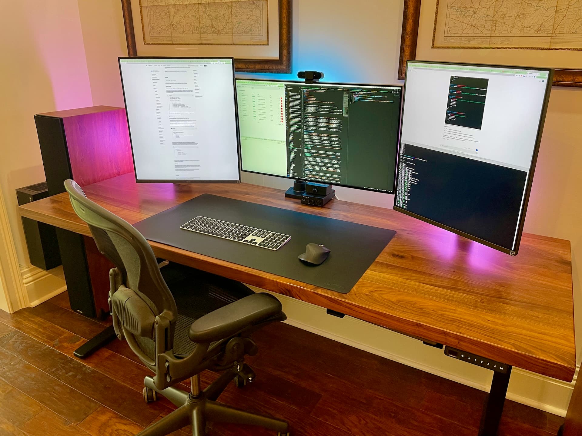 Picture of my desk setup, with a 32 inch 4k screen in the middle and 2 16:18 ratio screens on either side. Laptop stowed beneath.